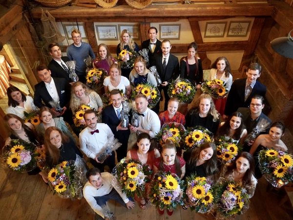 Einige Auzubildenede, die nach Beendigung der Ausbildung mit Blumensträußen verabschiedet werden 