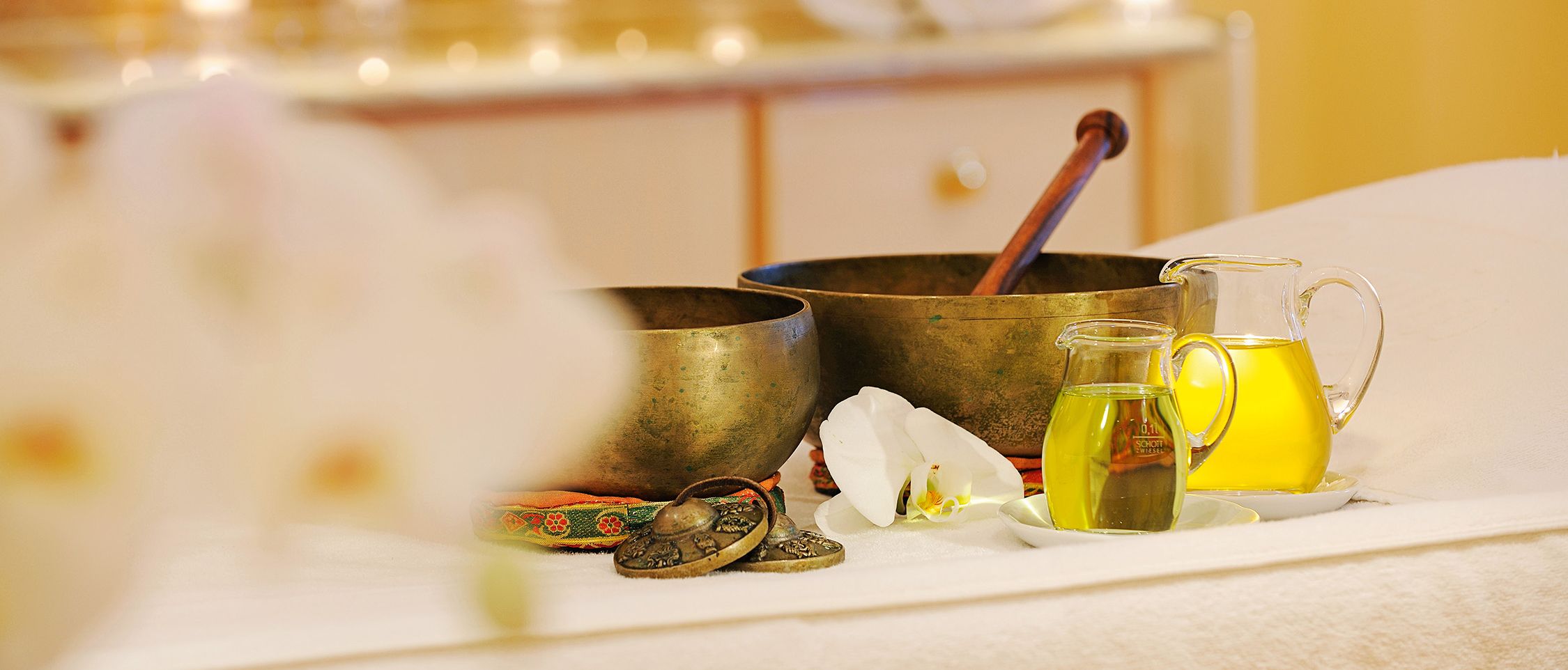 Detailaufnahme von goldenen Massageschalen und Massagezubehör