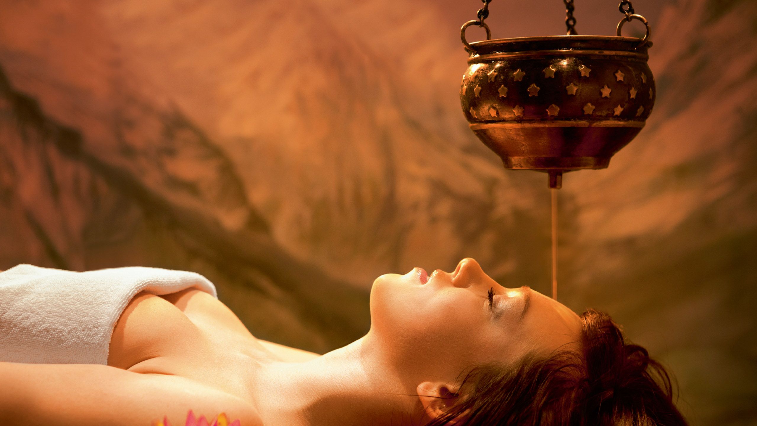 Eine Frau nur mit Handtuch bekleidet während einer Massagebehandlung im Spa Hotel Schwarzwald