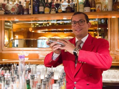 Ein Mitarbeiter hinter der Bar beim Cocktailmixen  