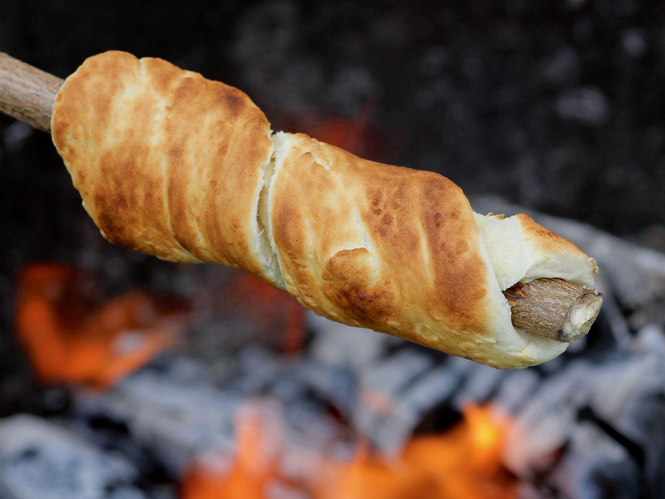 Detailaufnahme von Stockbrot über einem offenen Feuer