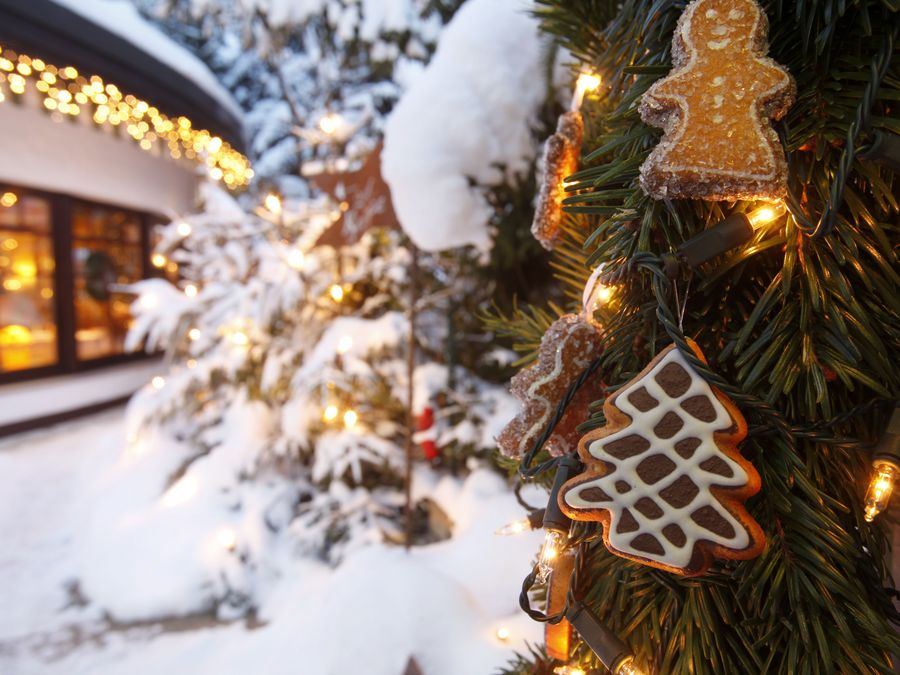 Der Ast eines geschmücktem Tannenbaums im verschneiten Garten des Hotel Bareiss