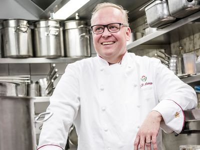 Aufnahme des lachenden Sternekochs Claus-Peter Lumpp in der Küche des 3 Sterne Restaurants