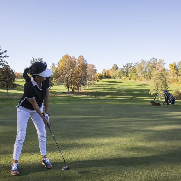 Aufnahme einer Golferin beim Abschlag auf dem Golfplatz