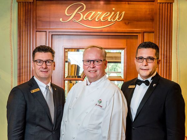 Thomas Brandt, Claus-Peter Lumpp und Teoman Mezda vor der Eingangstüre des Restaurant Bareiss