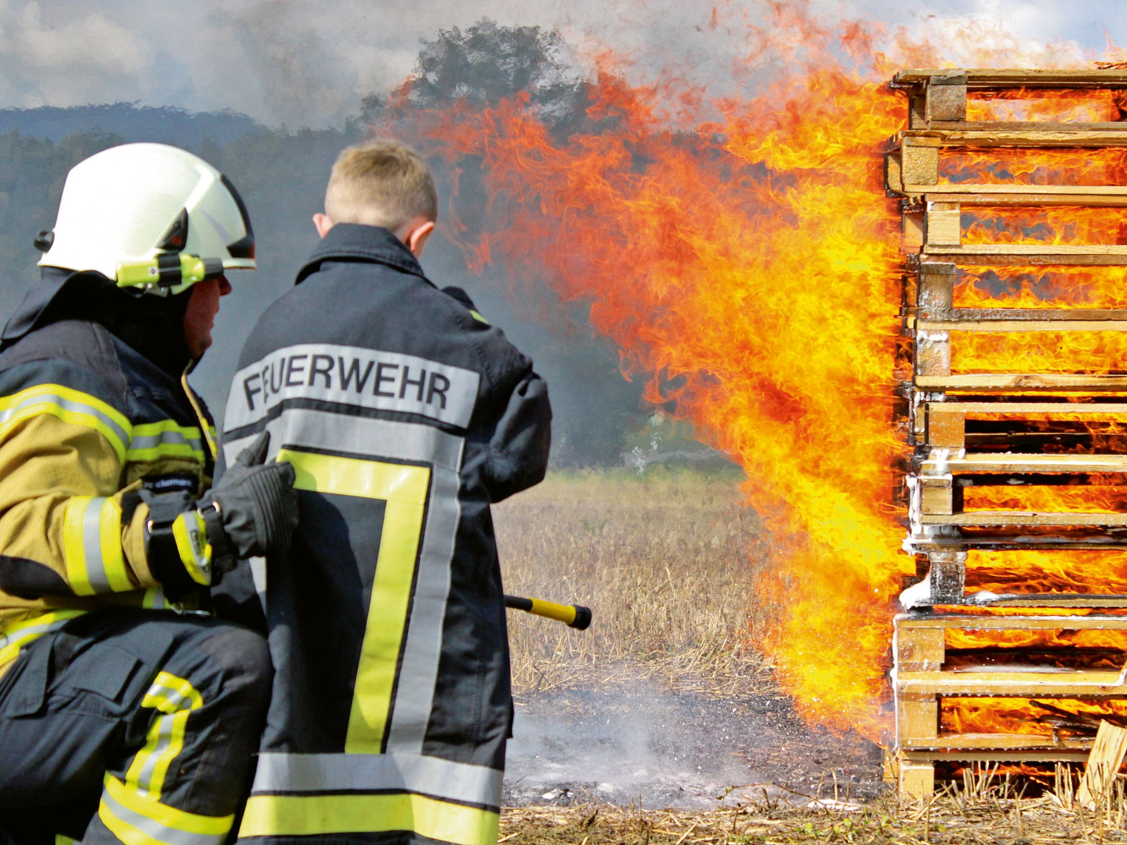 Zwei Feuerwehrmänner beim Löschen eines Feuers